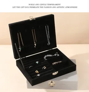 Detail of open black velvet jewelry box with necklace hooks and ring slots