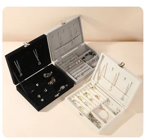 High-angle view of three velvet jewelry organizers in black, gray, and cream white.