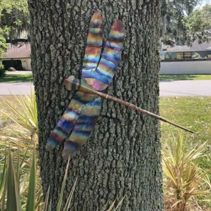 Outdoor metal dragonfly sculpture detail shot, colorful garden wall art decor ornament.