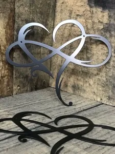 Metaal oneindigheid hart wandkunst detail, zwart ijzeren sculptuur voor rustieke kamerdecoratie.