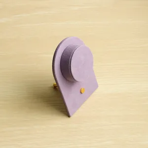 Gedetailleerde weergave van een paarse suède armbandhouder met gouden metalen knop