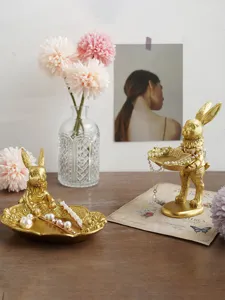 Vintage golden rabbit jewelry tray organizers displayed with pearls on a wooden table