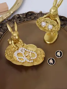 Macro view of golden retro rabbit figurines serving as creative jewelry display trays