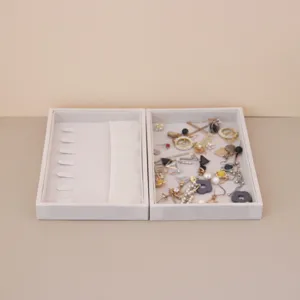 Detail of two suede jewelry organizer trays showing storage compartments and usage.