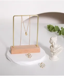 Detalle de un soporte para joyas de metal dorado y madera con collar y pendientes