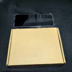 Scatola di imballaggio in carta kraft semplice con uno smartphone in una custodia trasparente.