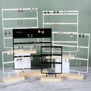 Detailed view of multi-layered iron earring organizer with wooden base in black and white