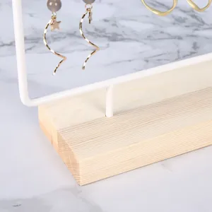 Detailed close-up showing the solid wood base and white metal frame of the jewelry stand