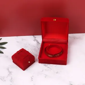 Elegant red flocked velvet jewelry gift boxes for rings and bracelets displayed on marble