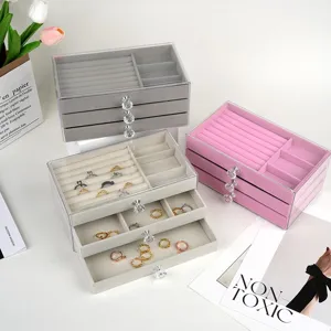 Detail view of three-layer velvet jewelry storage boxes in grey, pink, and beige colors