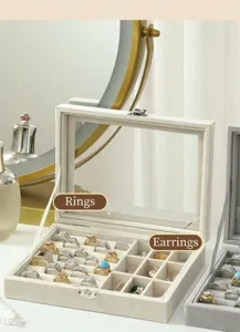 Détail de boite à bijoux en velours avec fentes pour bagues et compartiments sous couvercle.
