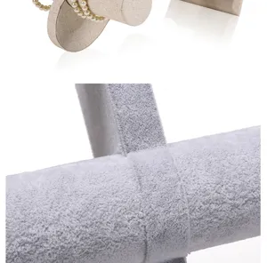 Detail view showing a close-up of soft grey velvet texture on jewelry display stand surface