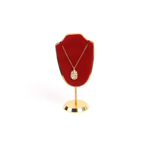 Detalle del soporte de collar de metal dorado y terciopelo rojo de alta gama