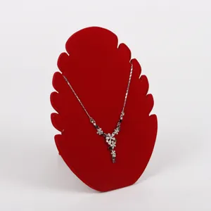 Primer plano de un lujoso expositor de joyas de terciopelo rojo en forma de llama con collar