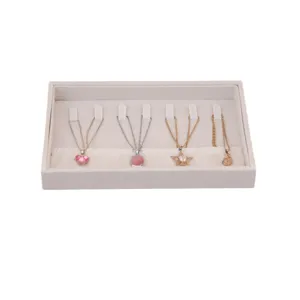 Elegant beige velvet jewelry tray with specialized slots for necklace display and storage