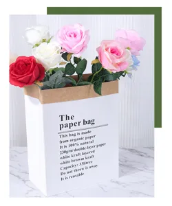 Detailansicht künstlicher Rosen Blumenstrauß in weißer Kraftpapier Geschenktüte.