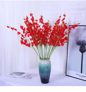 Artificial dancing orchid flower arrangement in ceramic vase for home decor detail