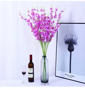 Artificial dancing orchid flower arrangement with glass vase for home decor table centerpiece.