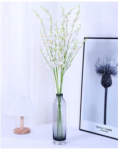 Artificial dancing orchid flowers in glass vase, elegant home decor detail showcase.
