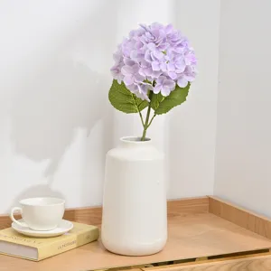 Artificial purple hydrangea flower in white ceramic vase for home decor wedding table.