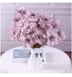 Detail view of purple artificial peony flower bouquet in white decorative vase for home.