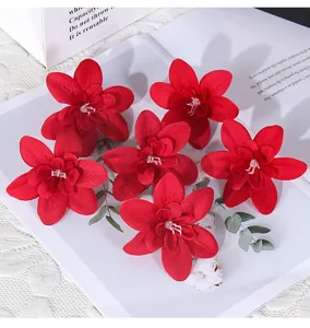 Nahaufnahme von leuchtend roten künstlichen Blumenköpfen für DIY-Hochzeitsarmbänder.
