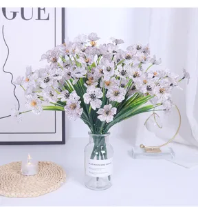 Artificial violet silk flowers bouquet in glass vase for home wedding and hotel room decor.