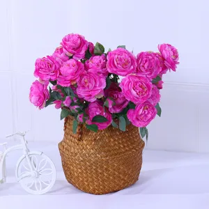 Artificial ranunculus rose flower bouquet in woven basket for home decor detail view.