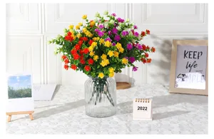 Detailed view of colorful artificial eucalyptus rose flowers in glass vase for home decoration.