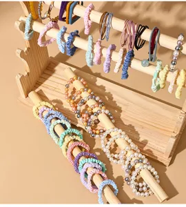 Dettaglio di espositore in legno massello per elastici per capelli e bracciali di perle.