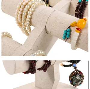 Detailed view of linen T-bar jewelry display stand holding various bead bracelets.