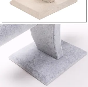Macro detail of high-quality velvet and linen jewelry display stand bases in grey and beige