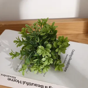Détail de plante verte artificielle miniature, petit feuillage réaliste pour décoration d'intérieur.