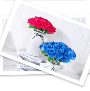 Detailansicht künstlicher roter und blauer Seidenrosen in Vasen als Heimdekoration.
