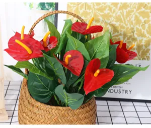 Artificial anthurium flower detail, red plastic plant in woven basket for home decor.