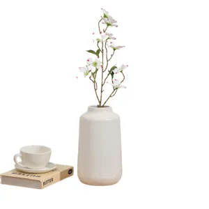 Vase en ceramique blanche avec fleurs artificielles, decoration interieure et accessoire.