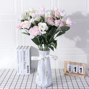 Artificial lisianthus flowers bouquet with white ceramic vase for home wedding decoration setup.
