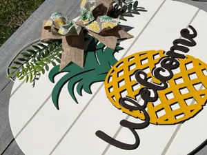 Detailansicht des hölzernen Ananas Willkommensschildes mit rustikaler Juteschleife und Deko.