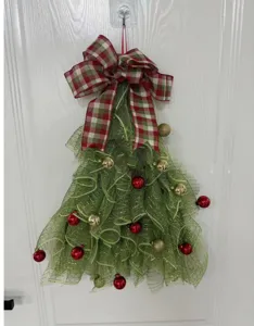 Detailansicht der handgefertigten Weihnachtsbaum-Türhängedeko mit grünem Netz und Schleife.
