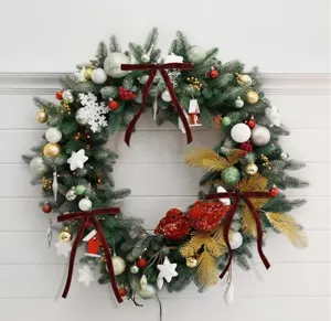 Christmas wreath with red velvet bows and pine branches for holiday home decoration.