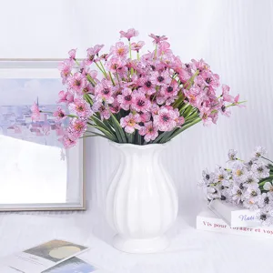 Artificial pink patterned flower bouquet in white ceramic vase for home decor setup.