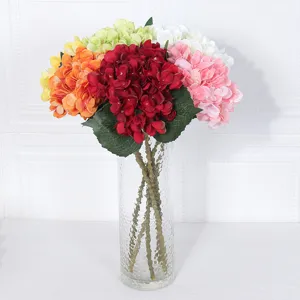 Colorful artificial hydrangea bouquet in clear glass vase for home wedding decor and party.