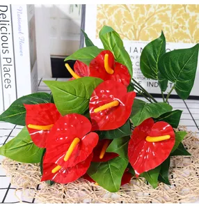 Artificial red anthurium detail shot, vibrant flower and green leaf arrangement for home decor.