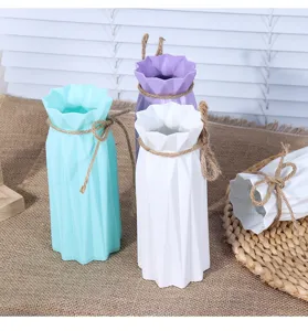 Close-up detail view of modern minimalist plastic vases featuring elegant twine bow decorations.