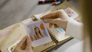 Détail d'un album de scrapbooking en kraft DIY montrant le placement de photos et souvenirs.