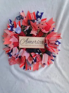 Close-up detail of American Independence Day decorative wreath with red white and blue ribbons.