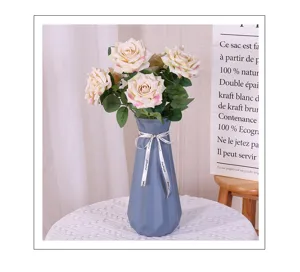 Nahaufnahme des eleganten künstlichen Rosenstrauchs in blauer dekorativer Vase für Zuhause.