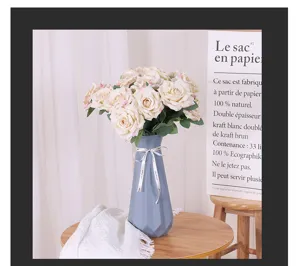 Detailansicht künstlicher Rosenblüten in blauen Vase für die schöne Heimdekoration.