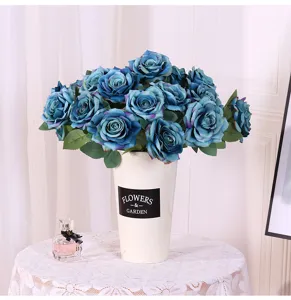 Detailaufnahme des künstlichen blauen Rosenstraußes mit weißer Vase für Heimdekoration.