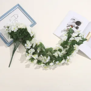 Vue détaillée de fausses guirlandes de fleurs blanches pour décoration murale.